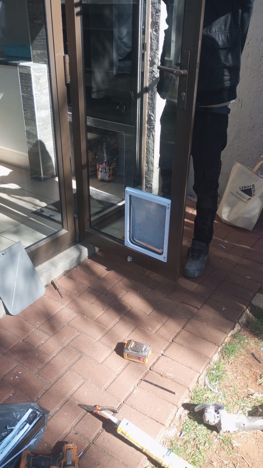 Aluminium glass door being fitted with a pet flap