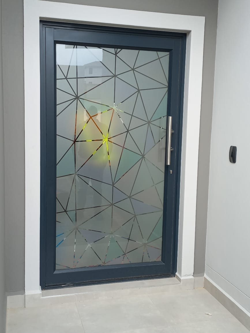 Aluminium pivot door with a geometric frosted glass design