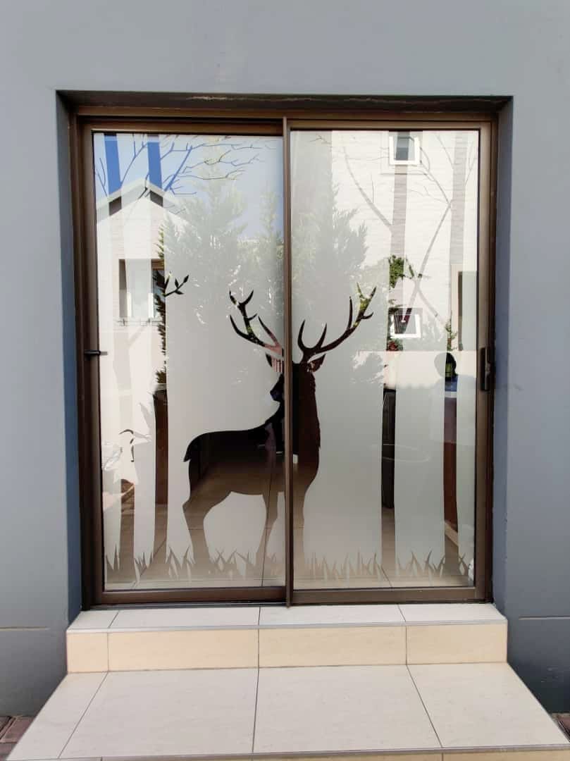 Aluminium sliding door with an etched deer glass design