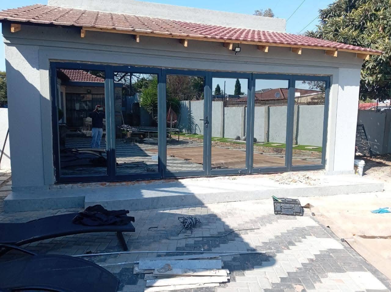 Aluminium stacking doors opening an entertainment room to the yard