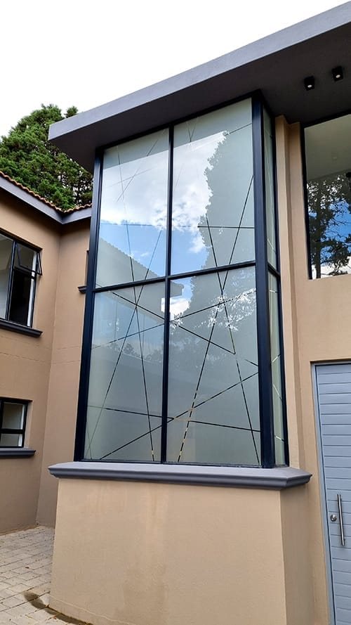 Black aluminium corner window on a double storey home