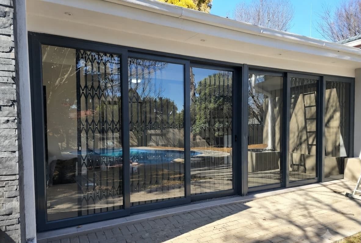 Black aluminium sliding doors with a view of the pool