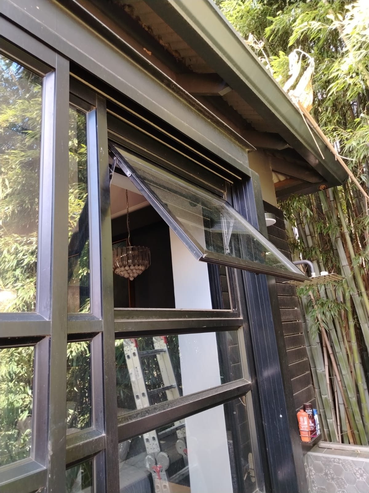 Bronze aluminium top hung windows being installed