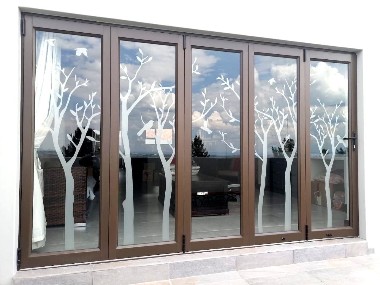 Bronze aluminium window with an etched tree glass design
