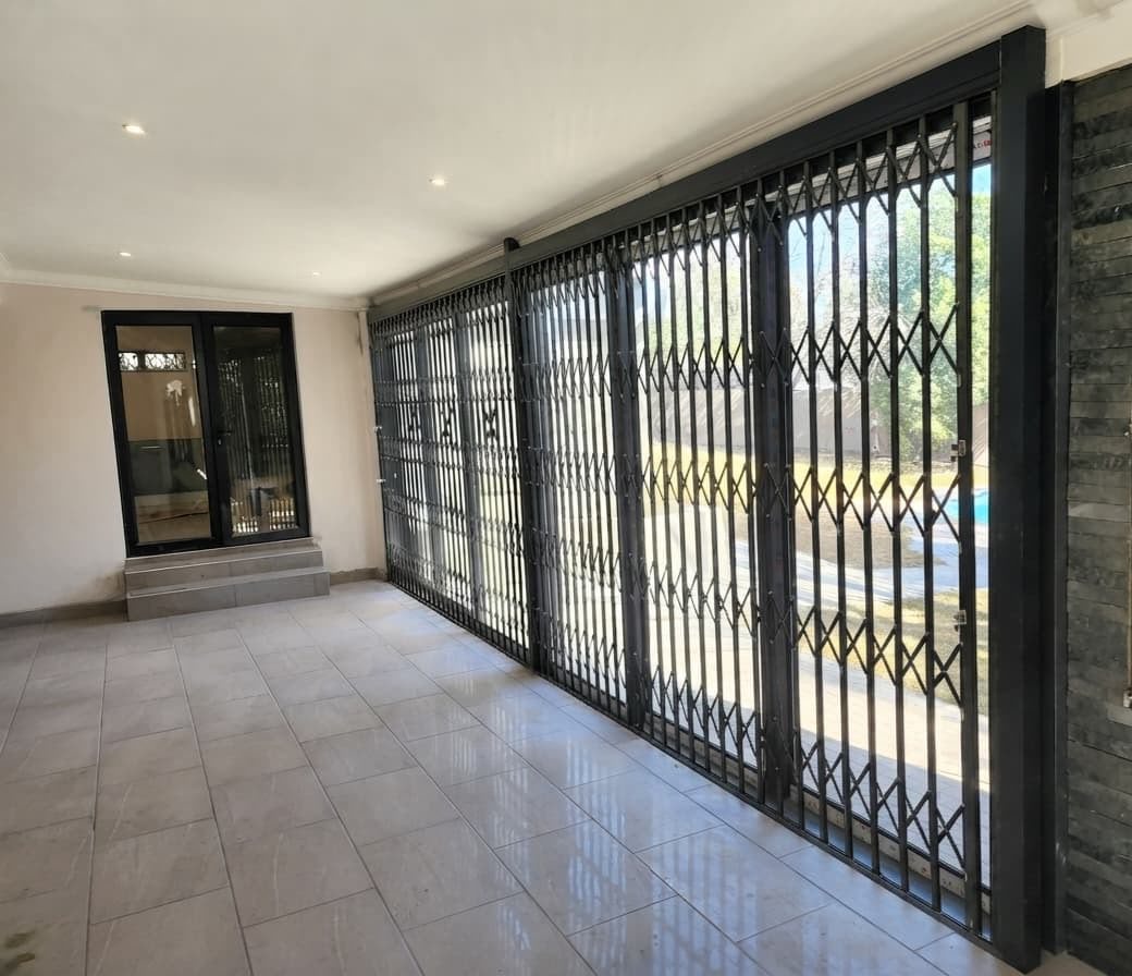 Long run of aluminium sliding doors with a trellis security gate