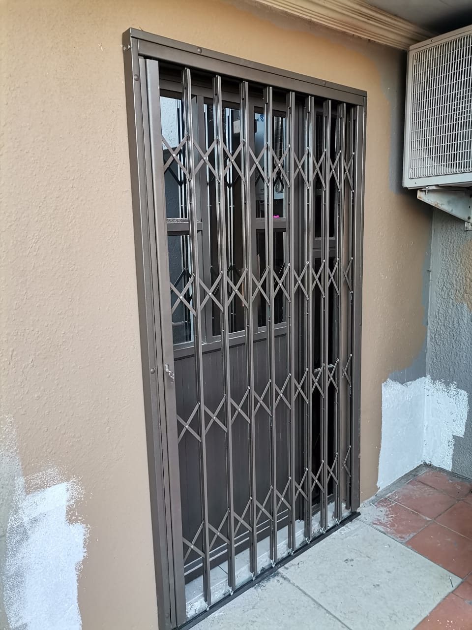 Trellis security door in a bronze frame